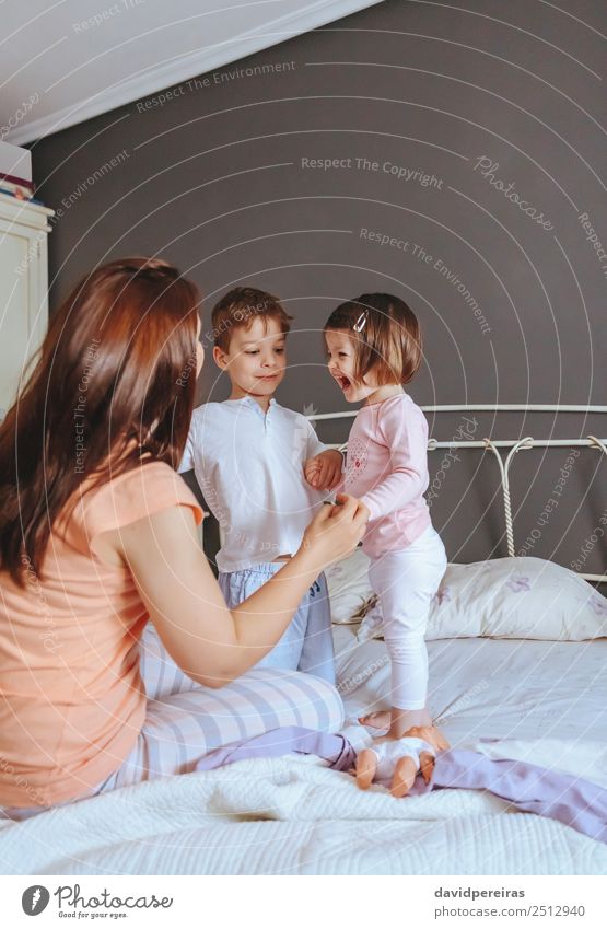 Entspannte Mutter und Söhne spielen über dem Bett. Lifestyle Freude Glück schön Erholung Freizeit & Hobby Spielen Schlafzimmer Kind Baby Junge Frau Erwachsene