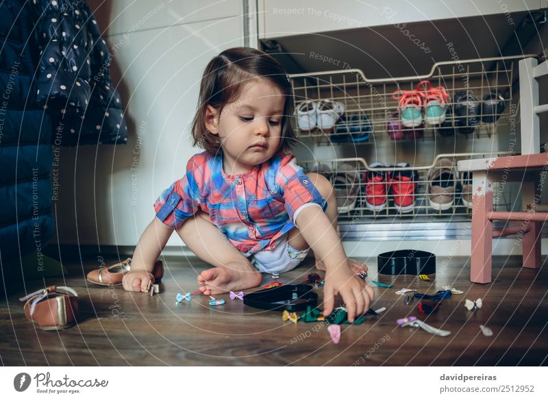 Baby Mädchen spielt mit Haarspangen, die auf dem Boden sitzen. Lifestyle Freude schön Spielen Haus Kind Mensch Frau Erwachsene Kindheit Hand Mode Bekleidung