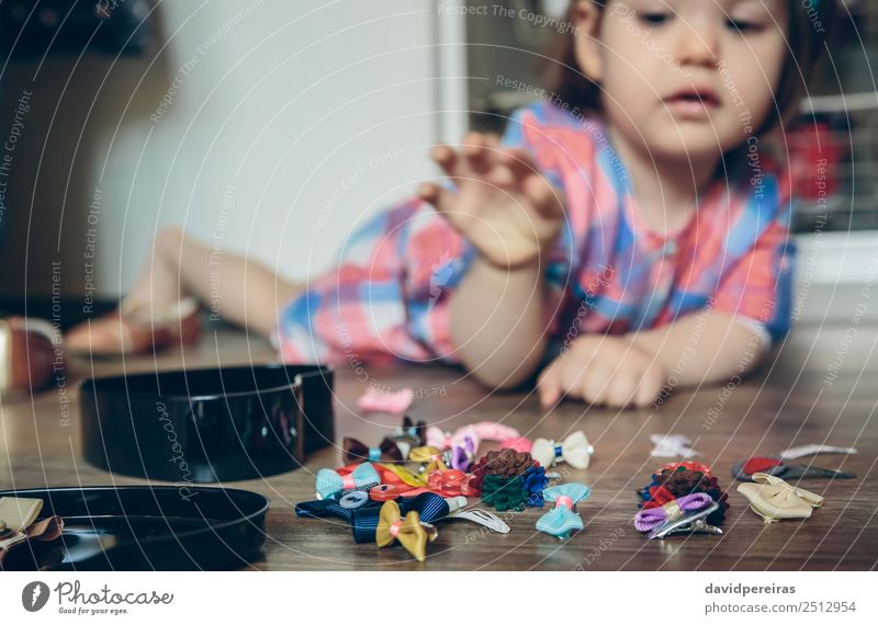 Baby Mädchen spielt mit Haarspangen, die auf dem Boden liegen. Lifestyle Freude Glück schön Spielen Haus Kind Mensch Frau Erwachsene Kindheit Hand Bekleidung