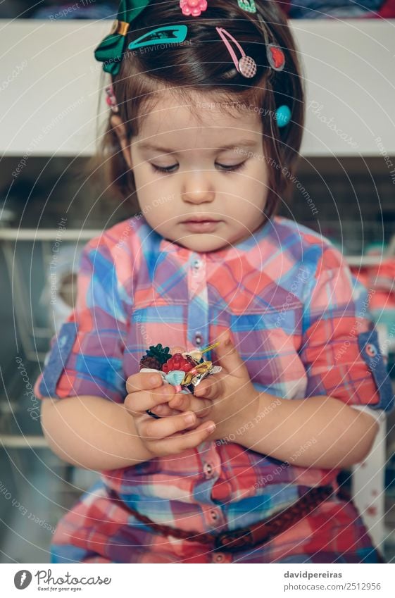 Babymädchen spielt mit Haarspangen in den Händen Lifestyle Freude Glück schön Spielen Haus Kind Mensch Kleinkind Frau Erwachsene Kindheit Hand Blume Mode