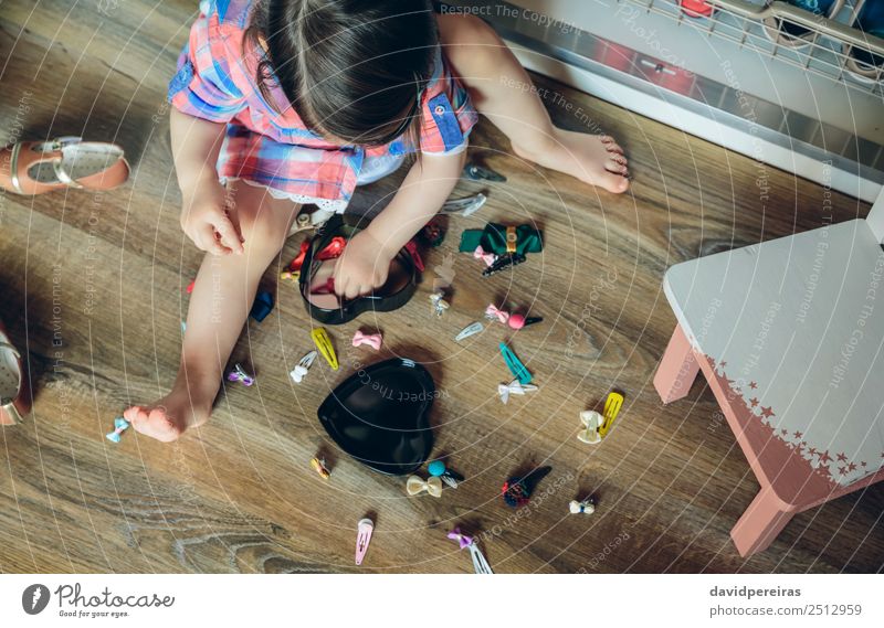 Baby Mädchen spielt mit Haarspangen, die auf dem Boden sitzen. Lifestyle Freude Glück schön Spielen Haus Kind Mensch Frau Erwachsene Kindheit Fluggerät Mode