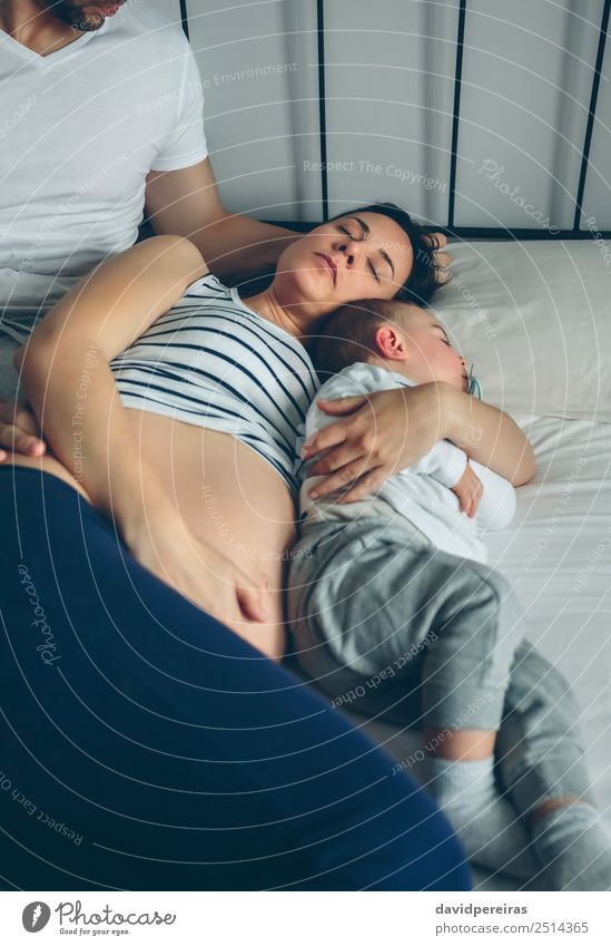 Mann sieht seine Frau und seinen Sohn an. Glück schön Erholung Schlafzimmer Kind Mensch Baby Kleinkind Erwachsene Eltern Mutter Vater Familie & Verwandtschaft