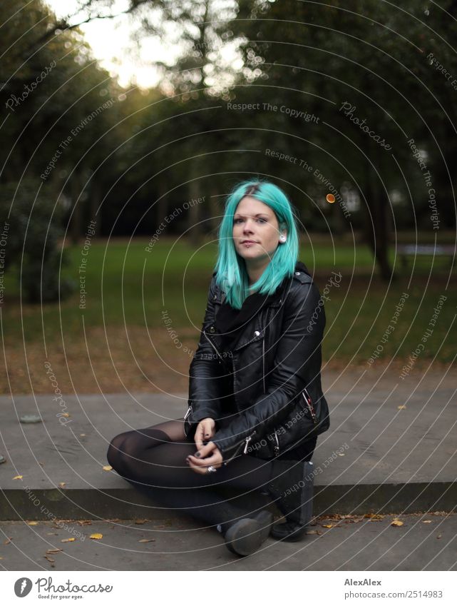 Junge Frau mit türkisen Haaren und Piercings schaut Stil schön Leben Jugendliche 18-30 Jahre Erwachsene Landschaft Schönes Wetter Park Lederjacke langhaarig