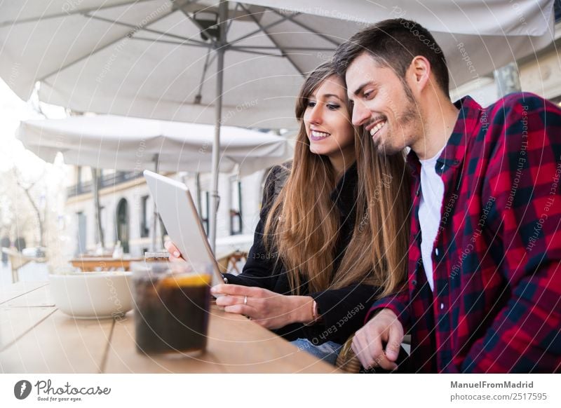 junges Paar auf der Terrasse sitzend Lifestyle Glück Freizeit & Hobby Ferien & Urlaub & Reisen Tisch Restaurant Computer Technik & Technologie Internet Frau