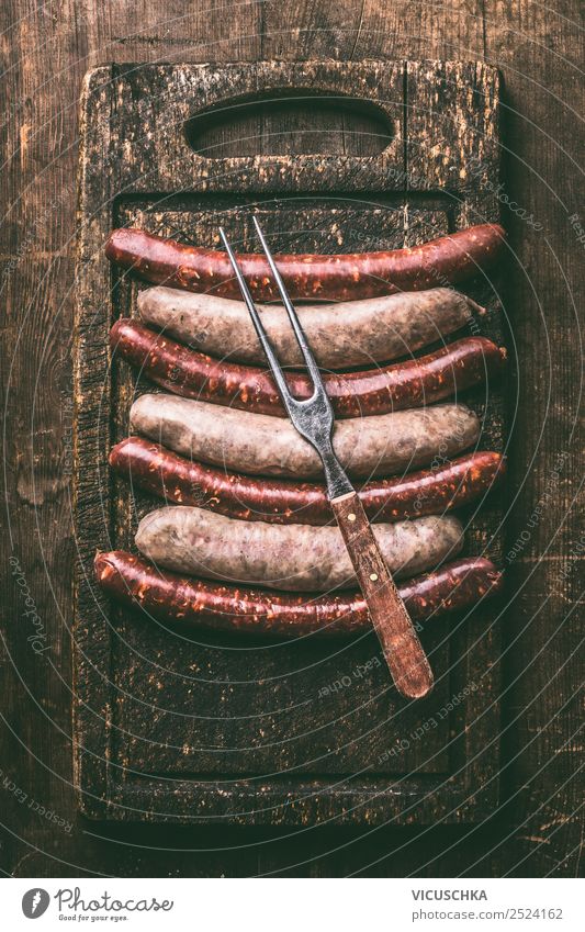 Bratwürste mit Fleisch Gabel Lebensmittel Wurstwaren Ernährung Stil Design Party Grill Bratwurst Auswahl Schneidebrett Holztisch Grillen Essen rustikal dunkel