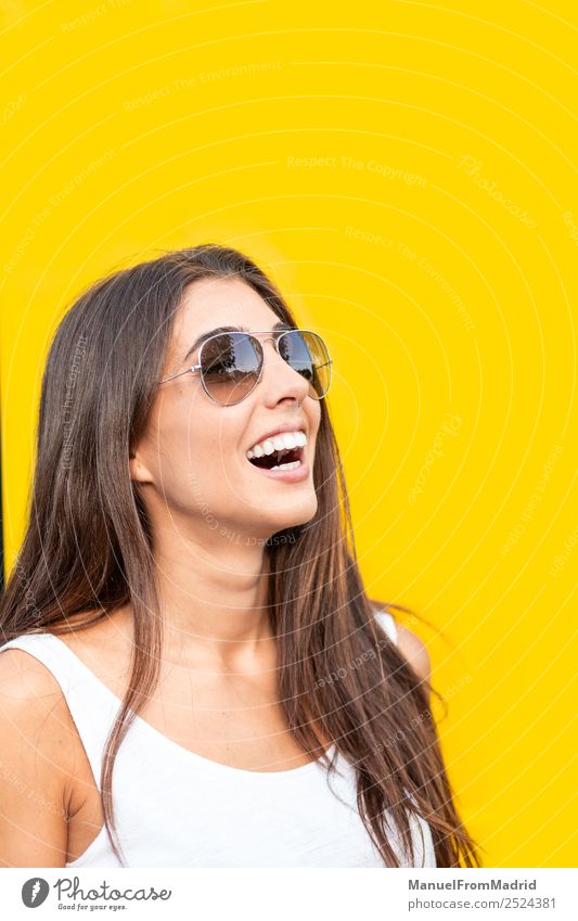 attraktive junge Frau mit Sonnenbrille auf gelbem Hintergrund Stil Freude Glück schön Sommer Mensch Erwachsene Mode Lächeln stehen trendy modern niedlich heiter