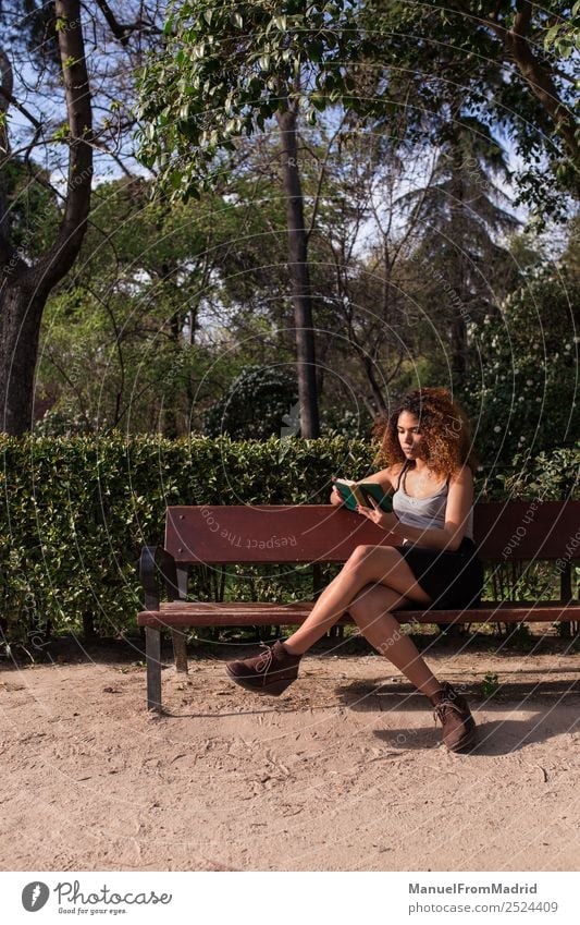 Afrofrau beim Lesen eines Buches auf einer Bank Lifestyle Glück schön Freizeit & Hobby lesen Sommer Schule lernen Mensch Frau Erwachsene Natur Baum Gras Park