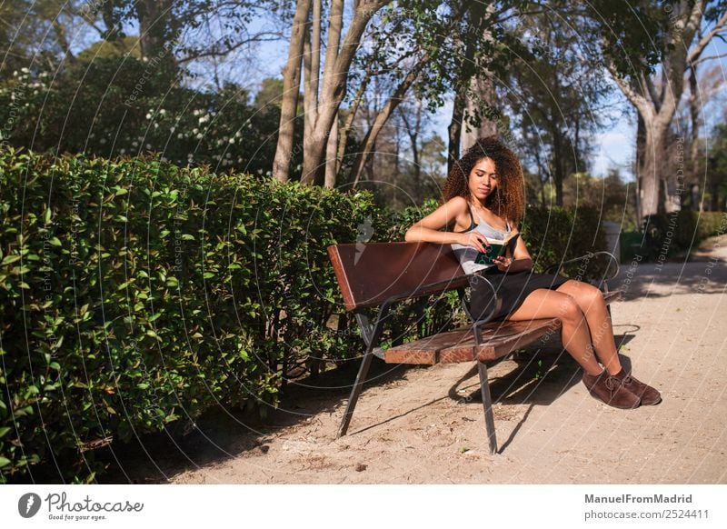 Afrofrau beim Lesen eines Buches auf einer Bank Lifestyle Glück schön Freizeit & Hobby lesen Sommer Schule lernen Mensch Frau Erwachsene Natur Baum Gras Park