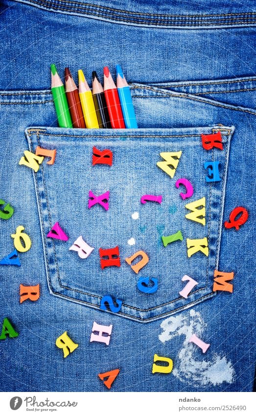 mehrfarbige Holzbuchstaben Design Schule Hose Jeanshose Stoff Schreibstift schreiben hell blau gelb rot weiß Farbe Kreativität Stil Alphabet Brief gestreut