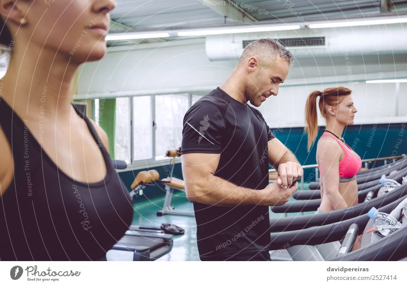 Mann, der die Herzfrequenz auf der Uhr überprüft, beim Laufband-Training. Lifestyle Sport Joggen Bildschirm Technik & Technologie Mensch Frau Erwachsene