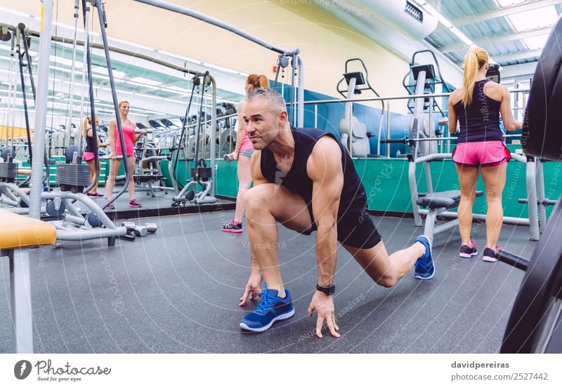 Männer, die sich dehnen und Frauen, die Kurzhantel-Übungen im Fitnessstudio machen. Lifestyle Glück schön Körper Freizeit & Hobby Club Disco Sport Mensch