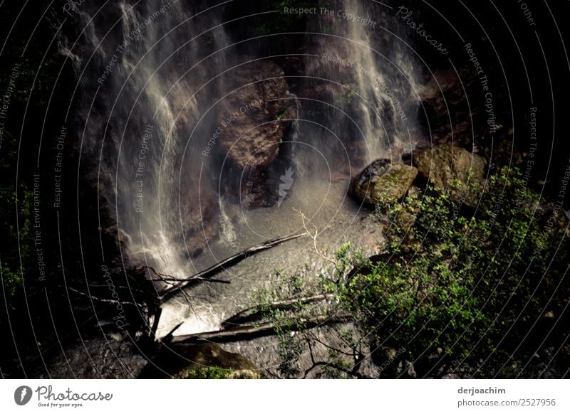 Krimi / hier geschah der Mord // Ein Wasserfall im Regenwald - Urwald in  Binna Barra. Das Wasser prasselt unten auf die Steine. Rechts sind ein paar grüne Büsche zu sehen. Queensland