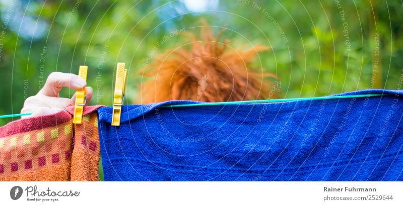 eine Frau hängt draußen Wäsche auf eine Wäscheleine feminin Erwachsene Haare & Frisuren Hand 1 Mensch rothaarig Arbeit & Erwerbstätigkeit Sauberkeit Tatkraft