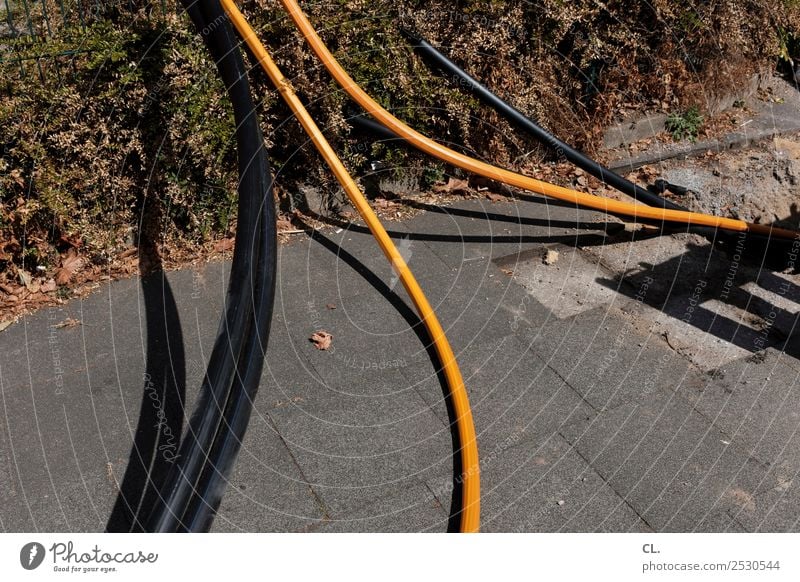 schläuche schlauchen Arbeit & Erwerbstätigkeit Baustelle Sträucher Verkehrswege Wege & Pfade Boden Schlauch kaputt orange schwarz Wandel & Veränderung Farbfoto