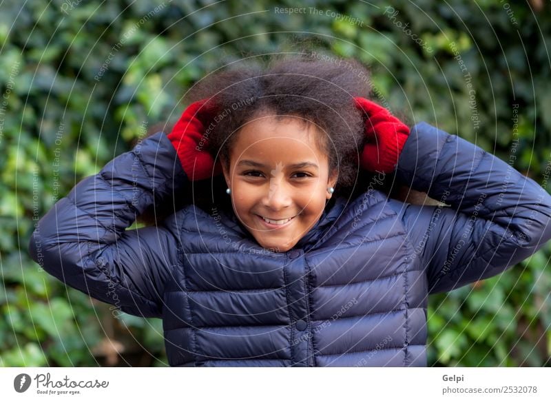 Hübsches Mädchen mit langem Afrohaar. Glück schön Gesicht Winter Garten Kind Mensch Frau Erwachsene Kindheit Park Mantel brünett Afro-Look Lächeln Fröhlichkeit