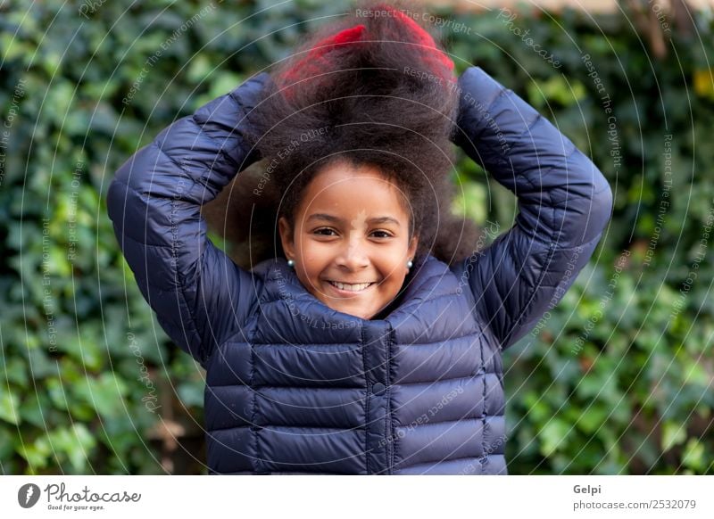 Hübsches Mädchen mit langem Afrohaar. Glück schön Gesicht Winter Garten Kind Mensch Frau Erwachsene Kindheit Park Mantel brünett Afro-Look Lächeln Fröhlichkeit