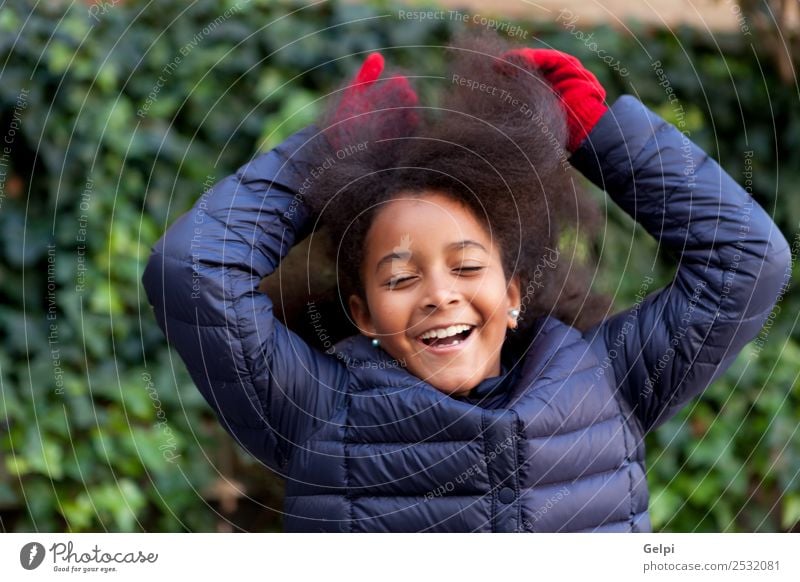 Hübsches Mädchen mit langem Afrohaar. Glück schön Gesicht Winter Garten Kind Mensch Frau Erwachsene Kindheit Park Mantel brünett Afro-Look Lächeln Fröhlichkeit