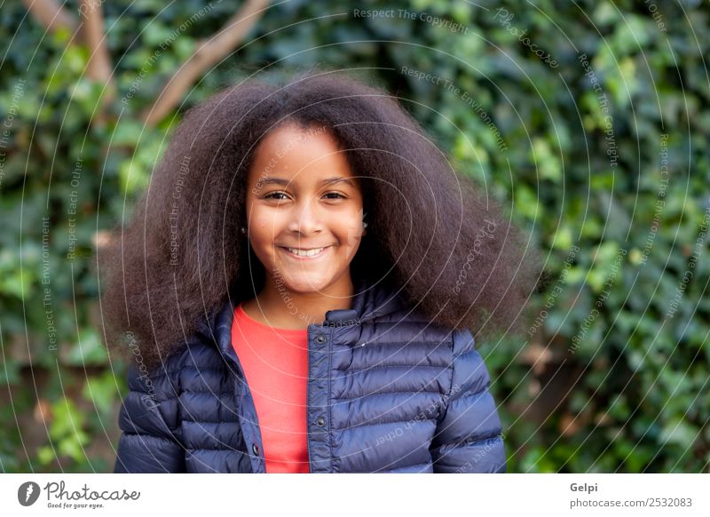 Hübsches Mädchen mit langem Afrohaar. Glück schön Gesicht Winter Garten Kind Mensch Frau Erwachsene Kindheit Park Mantel brünett Afro-Look Lächeln Fröhlichkeit