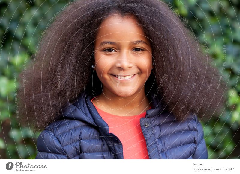 Hübsches Mädchen mit langem Afrohaar. Glück schön Gesicht Winter Garten Kind Mensch Frau Erwachsene Kindheit Park Mantel brünett Afro-Look Lächeln Fröhlichkeit