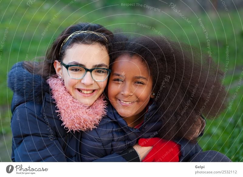 Zwei glückliche Mädchen im Park mit Mänteln. Freude Glück schön Gesicht Winter Kind Mensch Familie & Verwandtschaft Freundschaft Kindheit Gras Mantel Schal