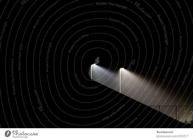 rationiertes Licht Lampe Sportstätten Fußballplatz Stadion Auffangnetz Auffangzaun Ballzaun Zaun Flutlicht Sportplatz Laterne Laternenpfahl dunkel hell schwarz