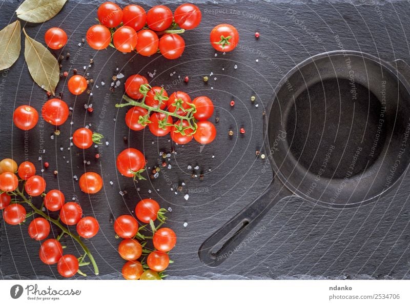 Pfanne und frische rote reife Kirschtomaten Gemüse Ernährung Mittagessen Vegetarische Ernährung Tisch Küche Essen klein natürlich oben grün schwarz Holzplatte