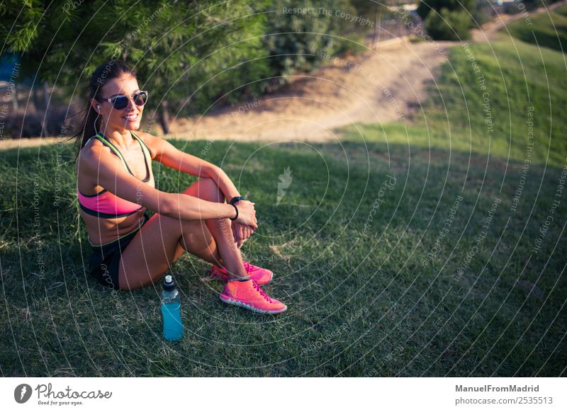 athletische Frau, die sich ausruht Flasche Lifestyle schön Sommer Sport Erwachsene Natur Park Fitness sitzen Energie Training Läufer aussruhen