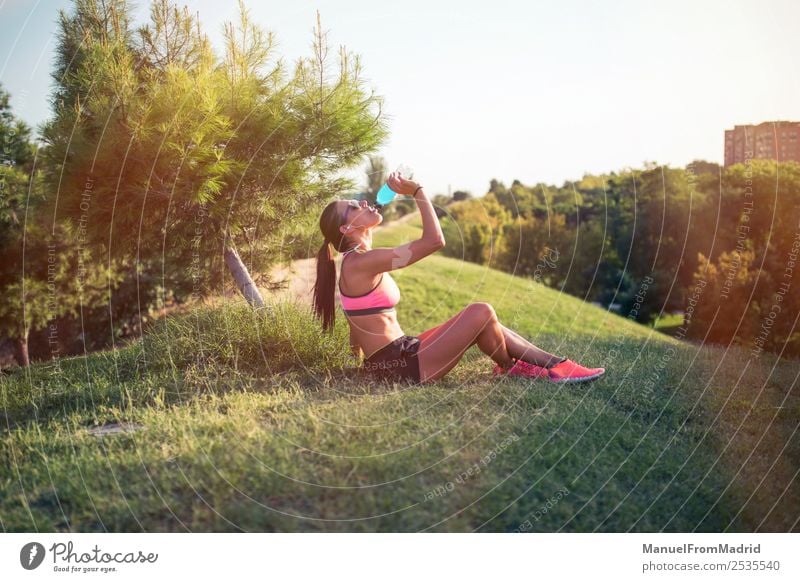 sportliche Frau, die sich ausruht und trinkt trinken Flasche Lifestyle schön Sommer Sport Erwachsene Natur Park Fitness sitzen Energie Training Läufer