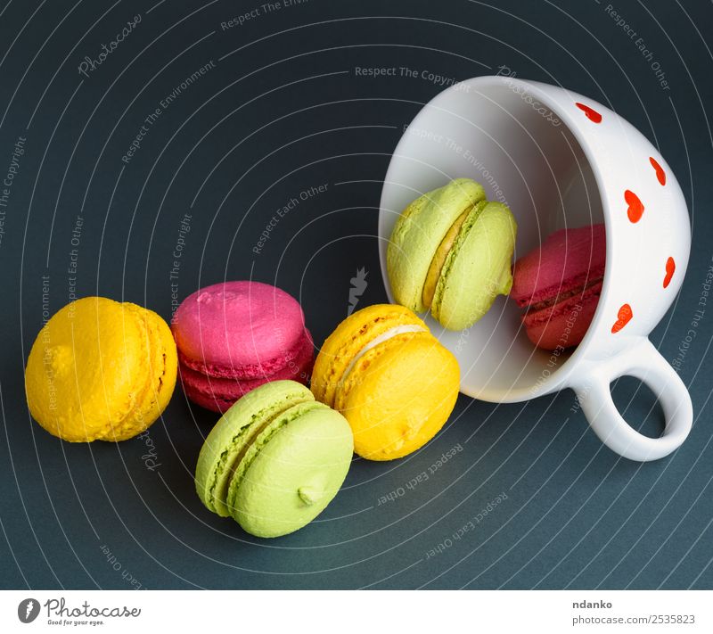 Makronen in einem weißen Keramikbecher Dessert Becher hell gelb rosa rot schwarz Farbe Macaron Tasse Hintergrund Lebensmittel farbenfroh Vanille Französisch