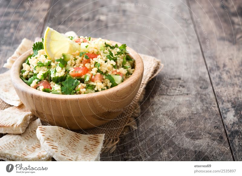 Tabbouleh-Salat auf Holztisch Tisch Salatbeilage Couscous Gemüse Tomate Gurke Salatgurke Petersilie Minze Vegane Ernährung Vegetarische Ernährung