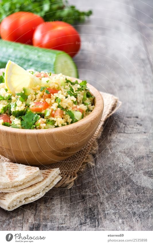 Tabbouleh-Salat und Zutaten auf Holz Tisch Salatbeilage Couscous Gemüse Tomate Gurke Salatgurke Petersilie Minze Vegane Ernährung Vegetarische Ernährung