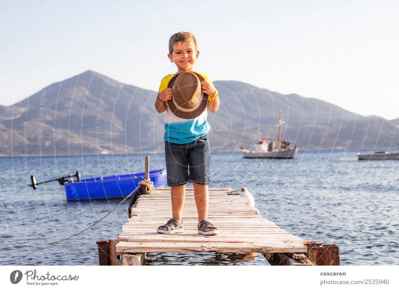 Porträt eines kleinen Kindes auf einem Dock mit einem Hut in der Hand. Lifestyle Glück schön Erholung Freizeit & Hobby Ferien & Urlaub & Reisen Sommer Strand