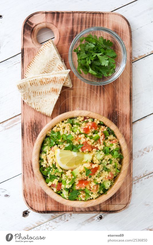 Tabbouleh-Salat mit Couscous auf weißem Tisch Salatbeilage Gemüse Tomate Gurke Salatgurke Petersilie Minze Vegane Ernährung Vegetarische Ernährung Gesundheit