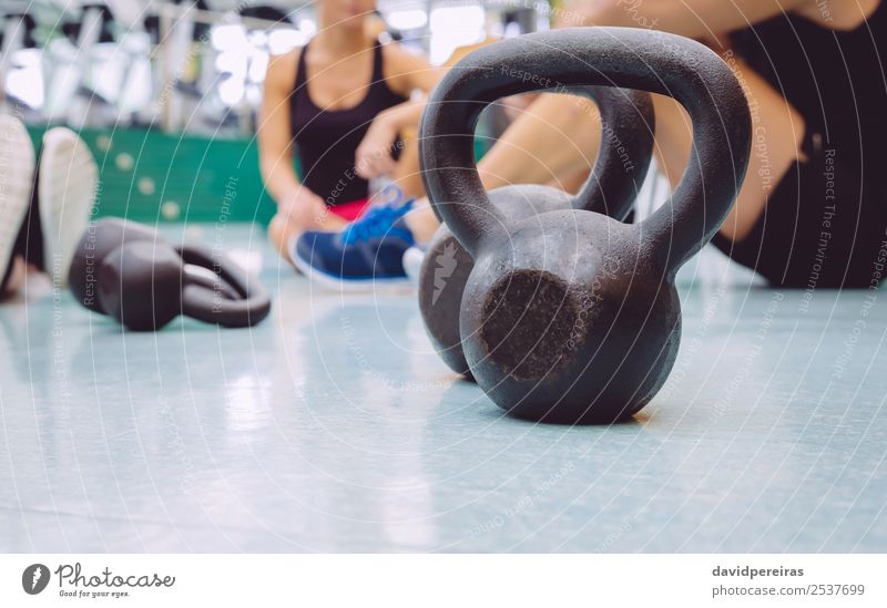 Schwarze eiserne Kugelglocke auf dem Boden des Fitnesscenters Lifestyle Körper Club Disco Sport Frau Erwachsene Mann Freundschaft Menschengruppe authentisch