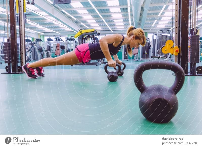 Frau beim Pushup über Kettlebells im Crossfit-Training Lifestyle Körper Club Disco Sport Erwachsene Fitness authentisch muskulös stark schwarz Kraft Liegestütze