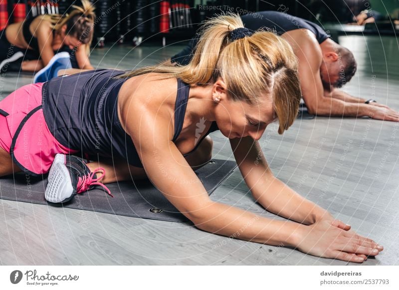 Frau bei Dehnungsübungen im Fitnessstudio Lifestyle Glück schön Körper Sport Schule Erwachsene Mann Arme Menschengruppe blond Zopf authentisch muskulös strecken