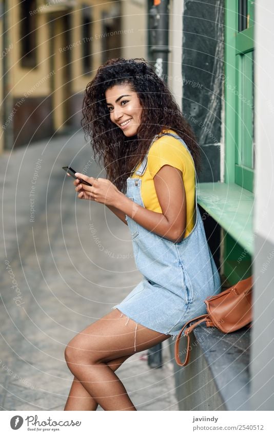 Afrikanische Frau, die mit ihrem Smartphone schreibt. Lifestyle Stil Glück schön Haare & Frisuren Telefon PDA Technik & Technologie Mensch feminin Mädchen