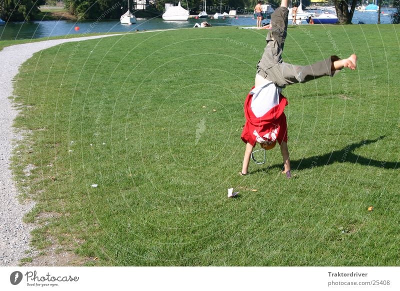 Erinnerung an den Sommer Wiese Kind Handstand Unbeschwertheit Spielen See Mann Sport Radschlagen Freude