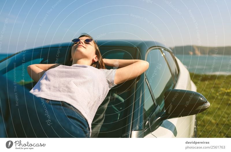 Junges Mädchen, das auf der Windschutzscheibe liegt. Lifestyle Stil Glück schön Erholung ruhig Ferien & Urlaub & Reisen Sonnenbad Meer Mensch Frau Erwachsene