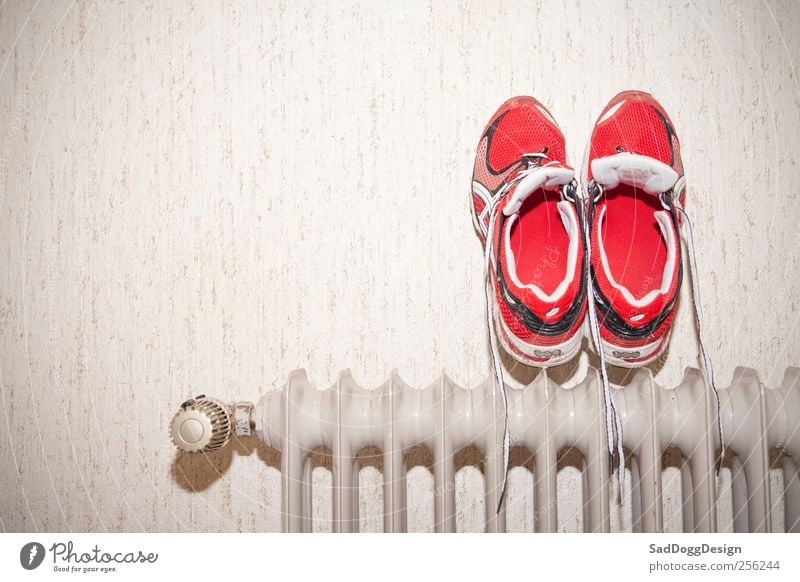 Nasse Füss' Joggen Schuhe nass retro Laufschuhe trocknen Sportbekleidung Heizkörper Turnschuh dreckig rot Laufsport Vignettierung Farbfoto Innenaufnahme