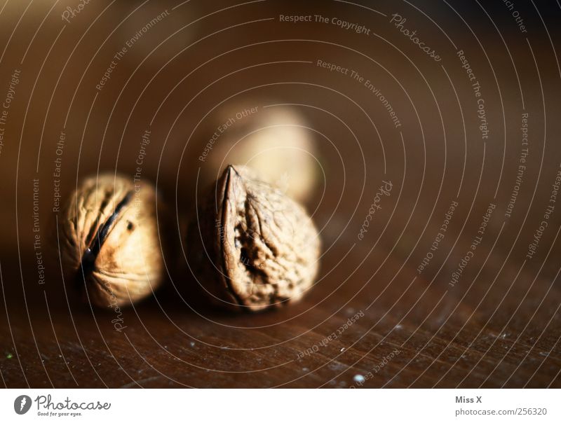 drei Nüsse für Aschenbrödel Lebensmittel Ernährung braun Nuss Nussschale Walnuss Hülle Holz Holzplatte hart Farbfoto Gedeckte Farben Innenaufnahme Nahaufnahme