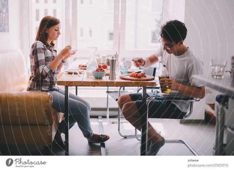 junges Paar beim gemeinsamen Frühstück in der Küche Gemüse Essen Kaffee Freude schön Stuhl Tisch sprechen Mensch Frau Erwachsene Mann Familie & Verwandtschaft