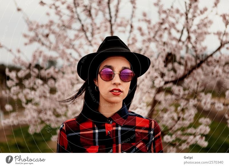 Mädchen Stil Glück schön Gesicht Garten Mensch Frau Erwachsene Natur Baum Blume Blüte Park Mode Sonnenbrille Hut brünett Lächeln Fröhlichkeit frisch lang