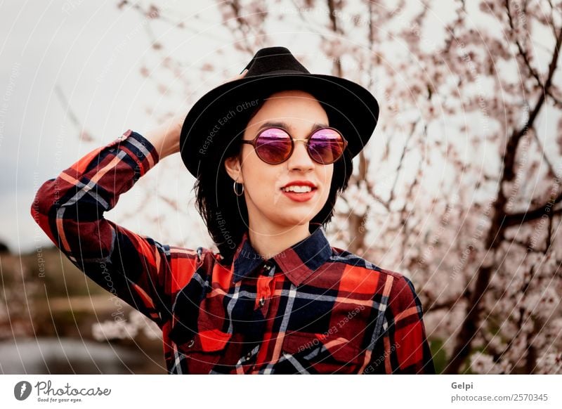 Mädchen Stil Glück schön Gesicht Garten Mensch Frau Erwachsene Natur Baum Blume Blüte Park Mode Sonnenbrille Hut brünett Lächeln Fröhlichkeit frisch lang