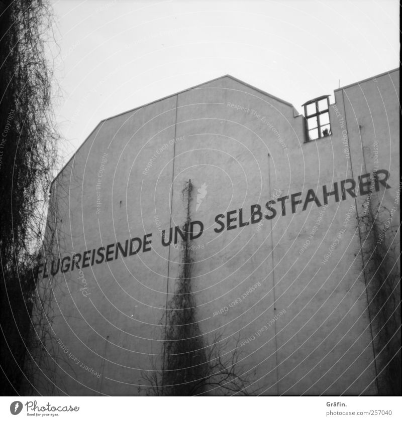 Flugreisende und Selbstfahrer Haus Gebäude Mauer Wand Stein Beton Schriftzeichen Graffiti authentisch Stadt grau schwarz weiß entdecken Surrealismus Buchstaben