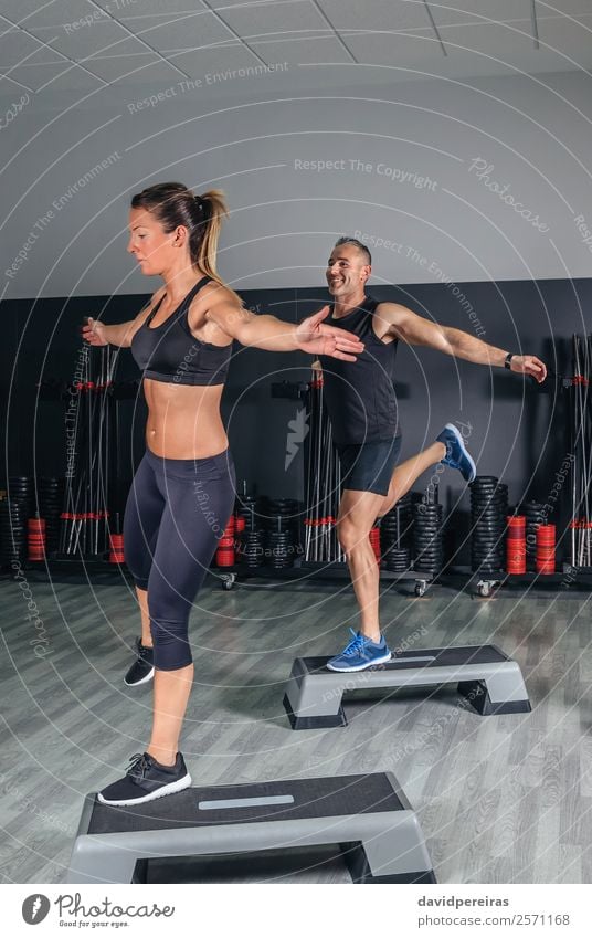 Paar, das Übungen über Schritte im Fitnessstudio macht. Lifestyle schön Körper Sport Mensch Frau Erwachsene Mann Freundschaft Liebe springen authentisch Erotik