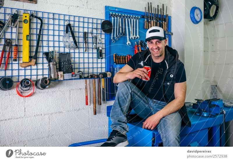 Motorradmechaniker, der sich ausruht und ein Bier trinkt. trinken Lifestyle Stil Glück Mensch Mann Erwachsene Fahrzeug Lächeln sitzen authentisch retro