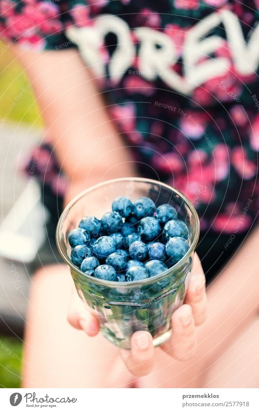 Mädchen, das es genießt, die frischen Heidelbeeren im Freien zu essen. Lebensmittel Frucht Dessert Ernährung Essen Vegetarische Ernährung Diät Glas Lifestyle