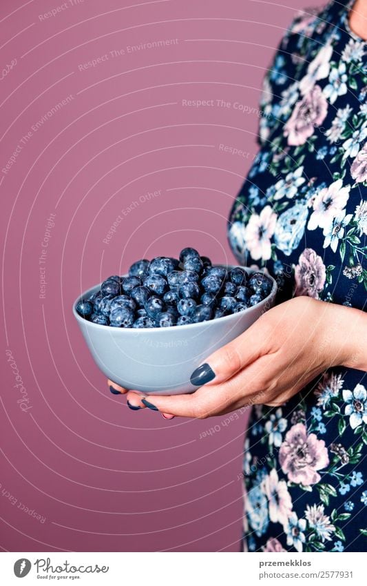 Frau hält eine Schüssel mit frischen Heidelbeeren gefüllt. Lebensmittel Frucht Ernährung Essen Bioprodukte Vegetarische Ernährung Diät Schalen & Schüsseln