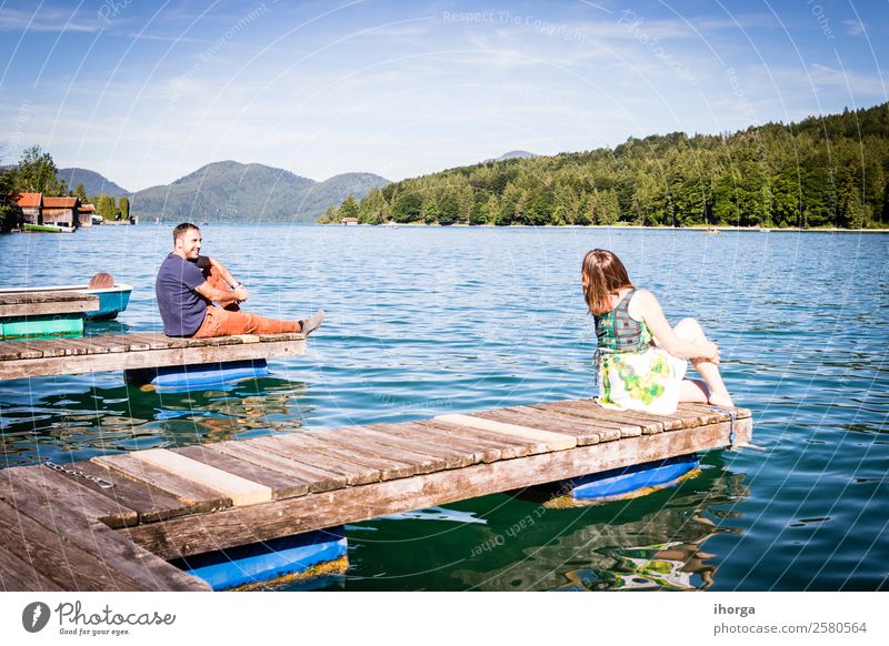 Zwei glückliche Liebende im Urlaub am Pier am See Lifestyle Glück schön Leben Erholung Ferien & Urlaub & Reisen Abenteuer Sommer Berge u. Gebirge Frau